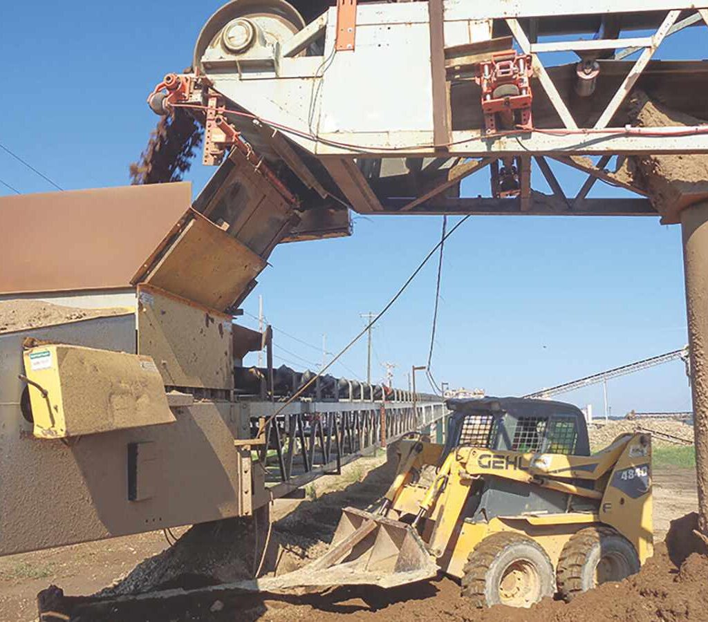 Un cargador frontal retira el material derramado en un punto de transferencia.| Foto: Martin Engineering
